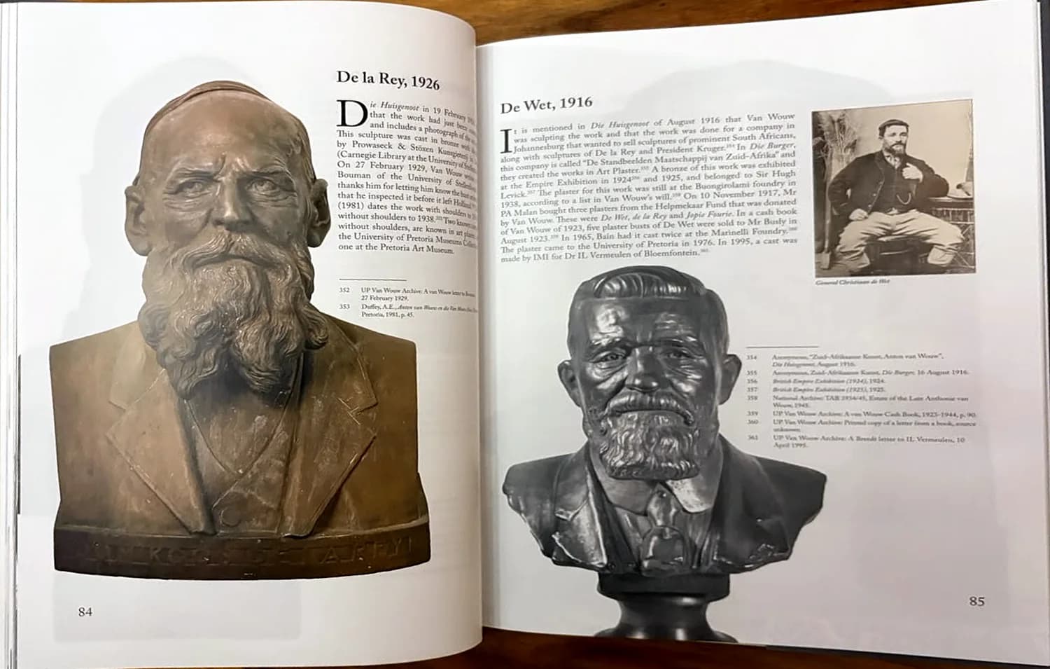 Book spread, pages 84 and 85: bronze busts of De la Rey (1926) and De Wet (1916) with catalogue text and an archival portrait